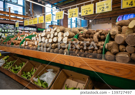 New york, usa august 18,2024. Supermarket produce section displaying various root vegetables like yams, malanga coco, and white yautia with price tags, alongside green plantains New york, usa august 18,2024. Supermarket produce section displaying various root vegetables like yams, malanga coco, and white yautia with price tags, alongside green plantains 139727497