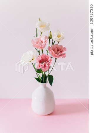 Beautiful white and pink Eustoma (Lisianthus) flowers in a vase on a pink pastel background. 139727530