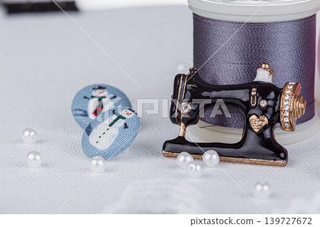 still life of a skein of thread for sewing, needles, buttons, sewing machine on a white background still life of a skein of thread for sewing, needles, buttons, sewing machine on a white background 139727672