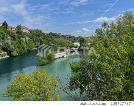 Scenic view of a river surrounded by lush greenery and residential buildings 139727787