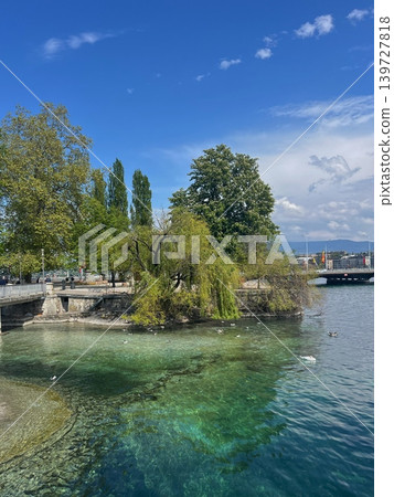 Scenic view of a tranquil lake with clear turquoise water, surrounded by Scenic view of a tranquil lake with clear turquoise water, surrounded by 139727818