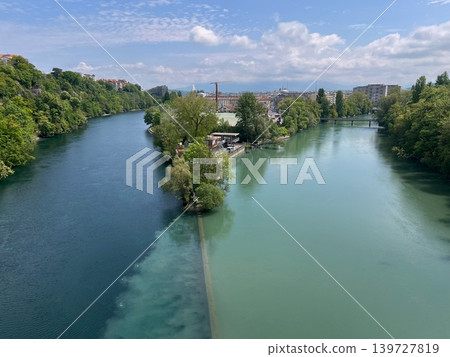 Scenic view of two rivers merging with distinct colors, surrounded by lush 139727819