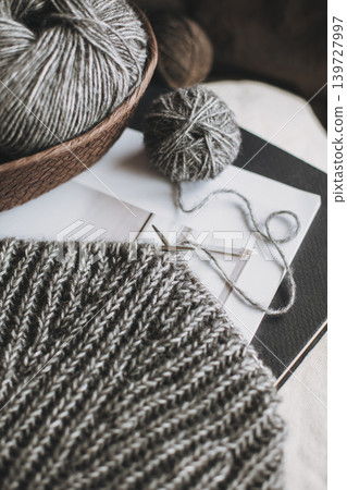Hand knitting with needles and yarn balls on a table. Concept for handmade and hygge slow life. 139727997