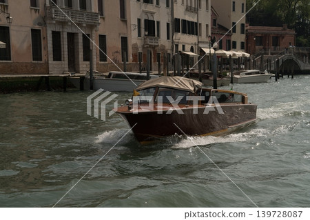 Wooden water taxi on Venice canal with historic buildings, Venice, Italy. Wooden water taxi on Venice canal with historic buildings, Venice, Italy. 139728087