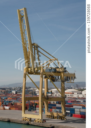 Yellow gantry crane at container terminal with stacked cargo containers Yellow gantry crane at container terminal with stacked cargo containers 139728088