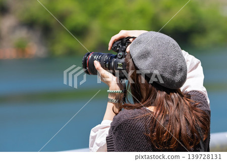 A woman photographs a lake in early summer at Lake Yamba-Agatsuma. 139728131