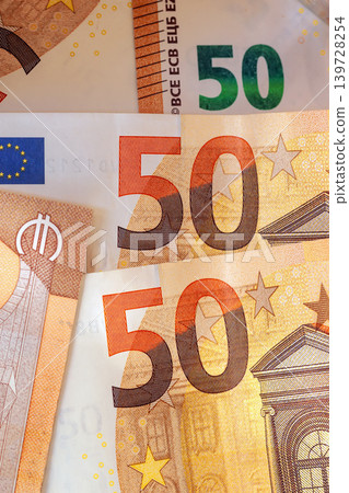 50 euro bills. Close up of euro banknotes with 50 denomination, security patterns, stars, architectural motifs on paper currency. Concept of euro banknotes for finance, banking, payment, savings 50 euro bills. Close up of euro banknotes with 50 denomination, security patterns, stars, architectural motifs on paper currency. Concept of euro banknotes for finance, banking, payment, savings 139728254