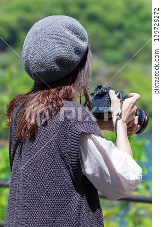 A woman photographs the early summer scenery at Lake Yamba-Agatsuma. A woman photographs the early summer scenery at Lake Yamba-Agatsuma. 139728272