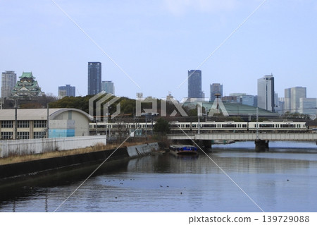 A Series 221 train on the Osaka Loop Line running through a cityscape with Osaka Castle towering over it (photographed on February 23, 2026). 139729088