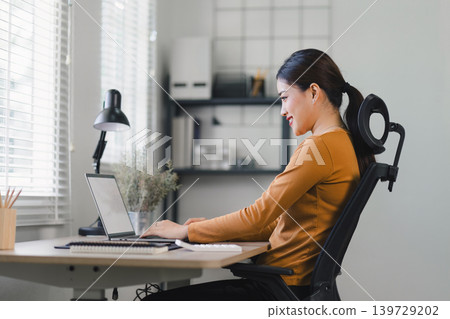 Young businesswoman working from home with laptop and documents. Work life balance concept Young businesswoman working from home with laptop and documents. Work life balance concept 139729202