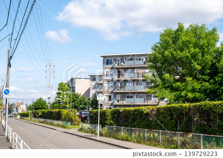 A housing complex with blue skies and lush greenery 139729223