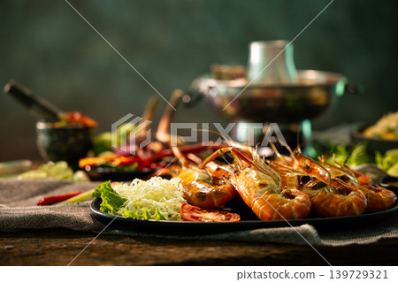 Close up grilled river prawns served with fresh vegetables, spicy seafood sauce and Thai herbs on rustic table, authentic Thai seafood cuisine and premium restaurant dining concept Close up grilled river prawns served with fresh vegetables, spicy seafood sauce and Thai herbs on rustic table, authentic Thai seafood cuisine and premium restaurant dining concept 139729321