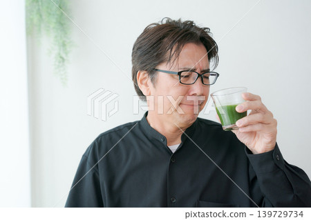 Middle male drinking green juice Middle male drinking green juice 139729734