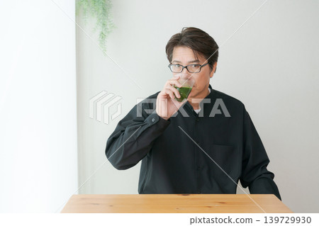 Middle male drinking green juice Middle male drinking green juice 139729930