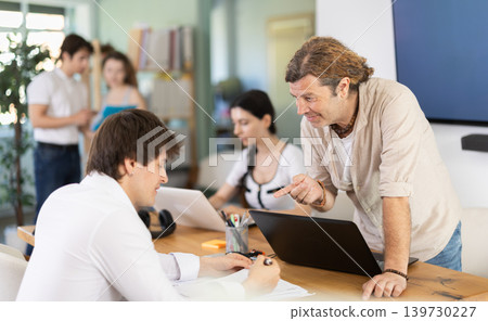 Several managers work together in a modern office. Well-coordinated management team 139730227