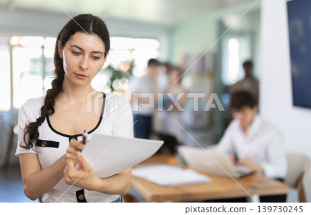 Female worker with a documents in his hands in office Female worker with a documents in his hands in office 139730245