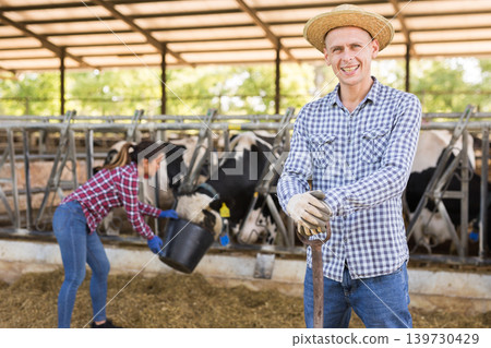 Male farmer posing in cowshed at the cow farm Male farmer posing in cowshed at the cow farm 139730429
