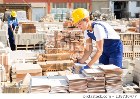Female worker carrying ceramic tiles at warehouse Female worker carrying ceramic tiles at warehouse 139730477