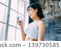 一位年輕女子正在喝礦泉水補充水分。 139730585