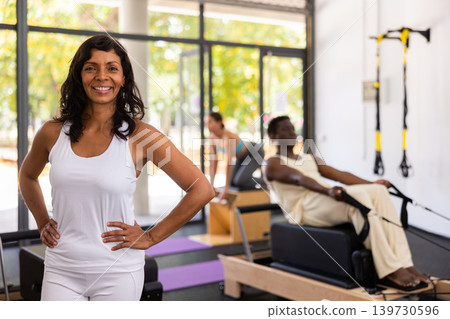 Positive hispanic female posing in fitness studio Positive hispanic female posing in fitness studio 139730596