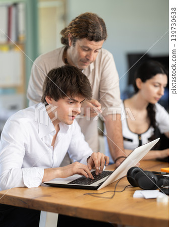Man helps guy complete task on laptop Man helps guy complete task on laptop 139730638