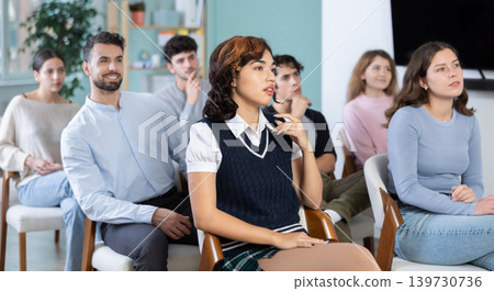 Group of young students listening during seminar in a modern classroom Group of young students listening during seminar in a modern classroom 139730736