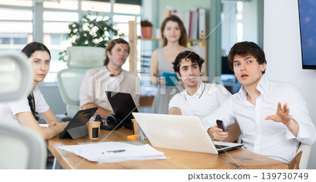 Group of colleagues watching presentation in office Group of colleagues watching presentation in office 139730749