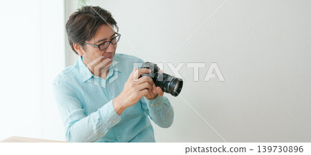 A man smiling with a camera in his hand. A man smiling with a camera in his hand. 139730896