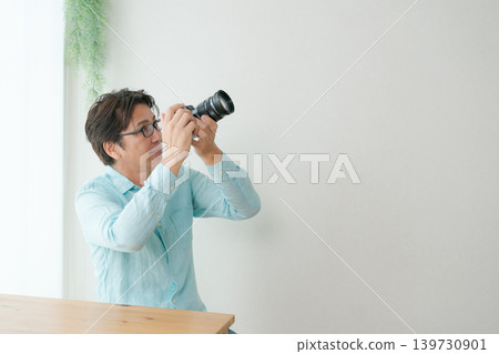 A man smiling with a camera in his hand. A man smiling with a camera in his hand. 139730901