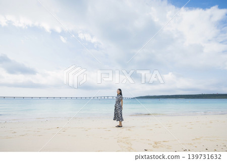 A woman looking at Kurima Bridge from Yonaha Maehama Beach. A woman looking at Kurima Bridge from Yonaha Maehama Beach. 139731632