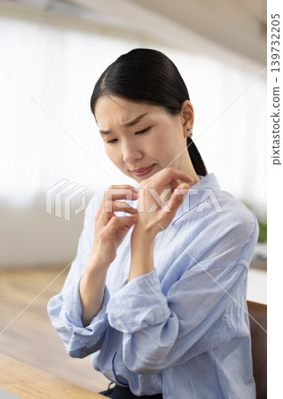 一位日本女子痛苦地搔著手。 139732205