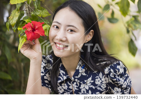 一位年輕女子正在和木槿花合照。 一位年輕女子正在和木槿花合照。 139732440