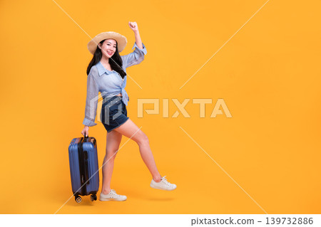 Happy Asian woman traveler standing and holding suitcase isolated on yellow background, Tourist girl having cheerful holiday trip concept, Full body composition. Happy Asian woman traveler standing and holding suitcase isolated on yellow background, Tourist girl having cheerful holiday trip concept, Full body composition. 139732886