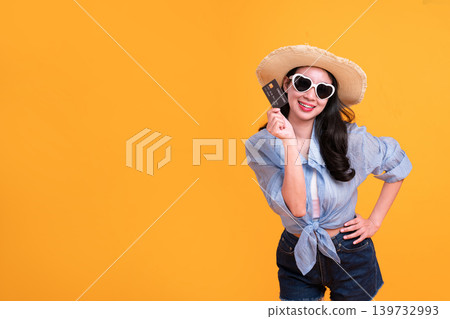 Excited Asian young woman in a sun hat and glasses to travel on holidays isolated on yellow copy space background. Travel, summer vacation, beach leisure concept. 139732993
