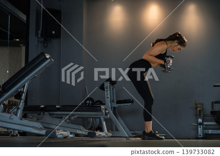 Fitness asian woman doing exercise and lifting dumbbells weights at sport gym. Fitness asian woman doing exercise and lifting dumbbells weights at sport gym. 139733082