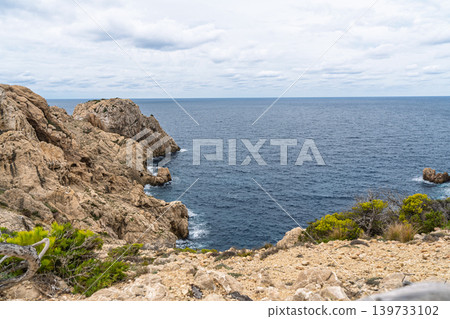 Rocky coastline of Menorca, Spain, with dramatic cliffs and blue sea views on a cloudy day Rocky coastline of Menorca, Spain, with dramatic cliffs and blue sea views on a cloudy day 139733102