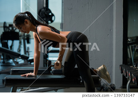 Fitness asian woman doing exercise and lifting dumbbells weights at sport gym. Fitness asian woman doing exercise and lifting dumbbells weights at sport gym. 139733147