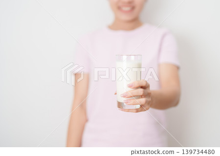 Healthy woman holding glass of fresh milk at home, female drinking milk for calcium and strong bones, high protein, dairy product for healthy lifestyle, wellness and daily routine concept Healthy woman holding glass of fresh milk at home, female drinking milk for calcium and strong bones, high protein, dairy product for healthy lifestyle, wellness and daily routine concept 139734480