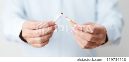 Man hand break cigarette for World No Tobacco Day concept, quitting smoking to prevent Lung Cancer, COPD, Emphysema and Tuberculosis disease. healthy lifestyle resolution, stop nicotine addiction 139734518
