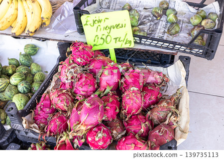 Fresh dragon fruit displayed at market with bananas and green fruits Fresh dragon fruit displayed at market with bananas and green fruits 139735113