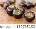 Pile of dark purple Indigo Rose cherry tomatoes on wooden table. 139735153