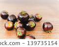 Pile of dark purple Indigo Rose cherry tomatoes on wooden table. 139735154