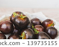 Fresh harvest of dark purple Indigo Rose heirloom tomatoes with water droplets in a bowl. 139735155