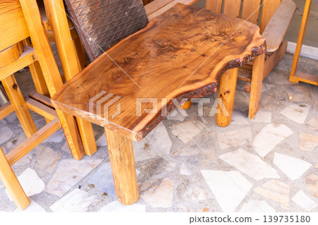 Rustic wooden table with unique shape and natural finish in workshop Rustic wooden table with unique shape and natural finish in workshop 139735180