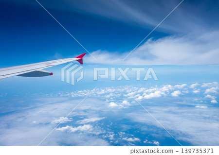 View from an airplane wing above the clouds View from an airplane wing above the clouds 139735371