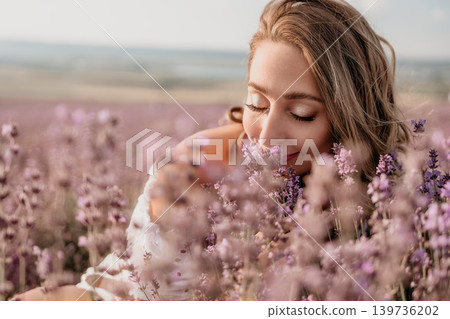 Lavender woman smell peaceful young lady enjoys the fragrance of blooming purple flowers in a sunny field at golden hour Lavender woman smell peaceful young lady enjoys the fragrance of blooming purple flowers in a sunny field at golden hour 139736202