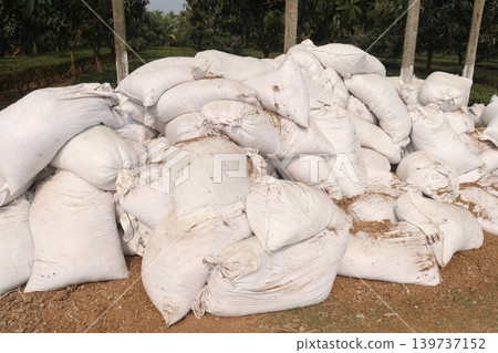 pile of white sacks with fertilizer on farm pile of white sacks with fertilizer on farm 139737152