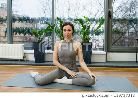 Young Woman Sitting On Yoga Mat In Studio Young Woman Sitting On Yoga Mat In Studio 139737318