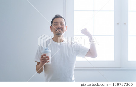 A middle-aged man holding a protein bottle. A middle-aged man holding a protein bottle. 139737360