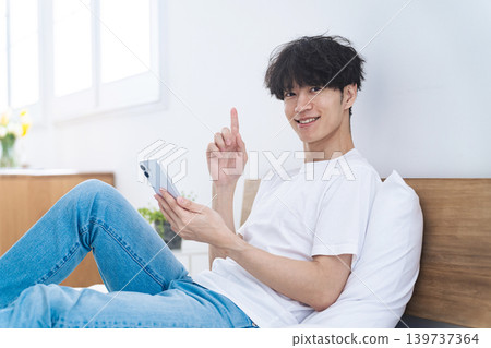 一名男子悠閒地使用智慧型手機。 一名男子悠閒地使用智慧型手機。 139737364